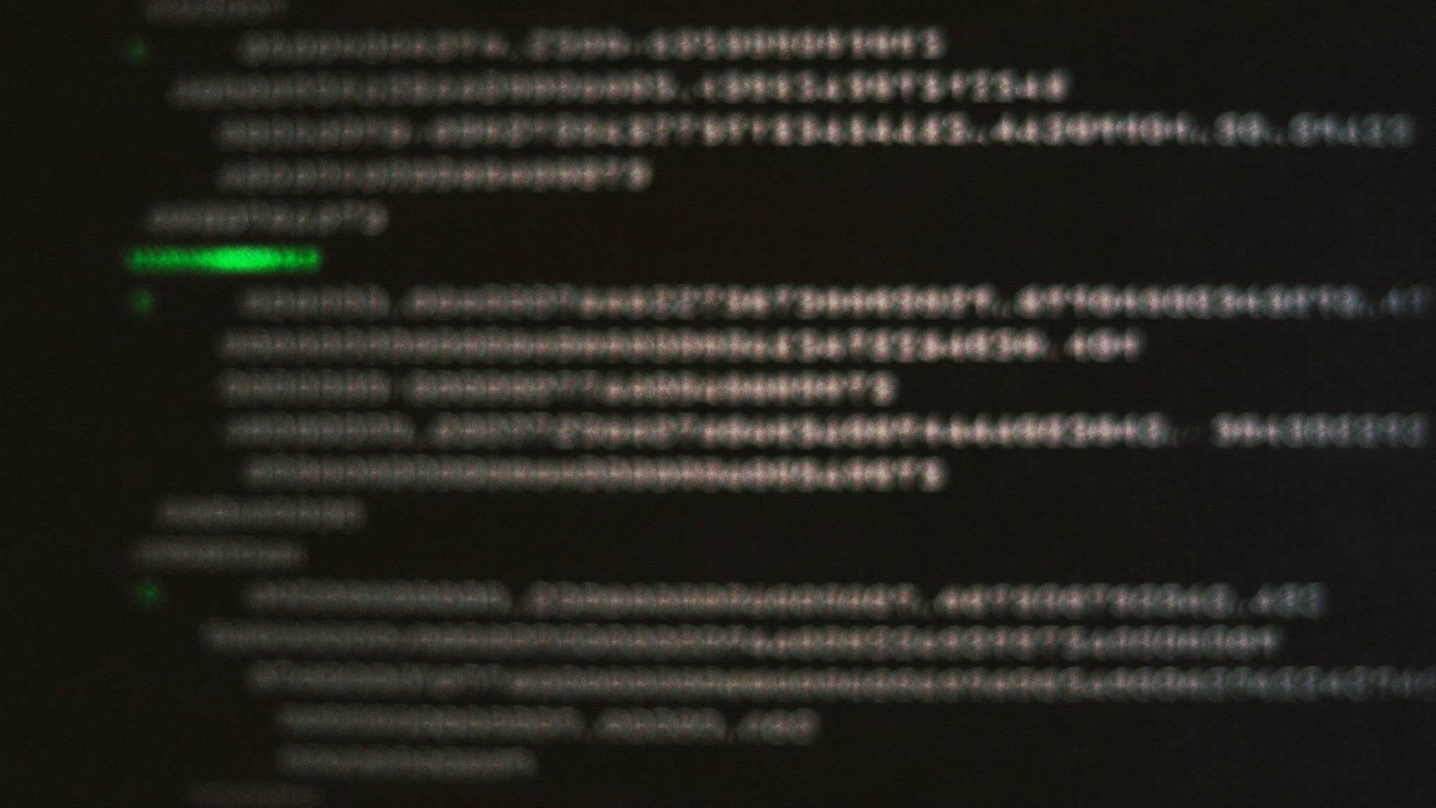 Out-of-focus lines of code on a dark monitor